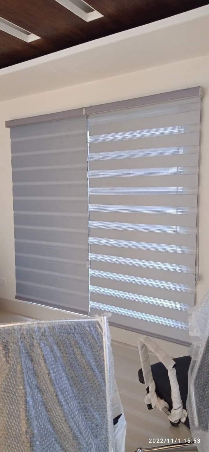 Grey zebra blinds half open in a living room