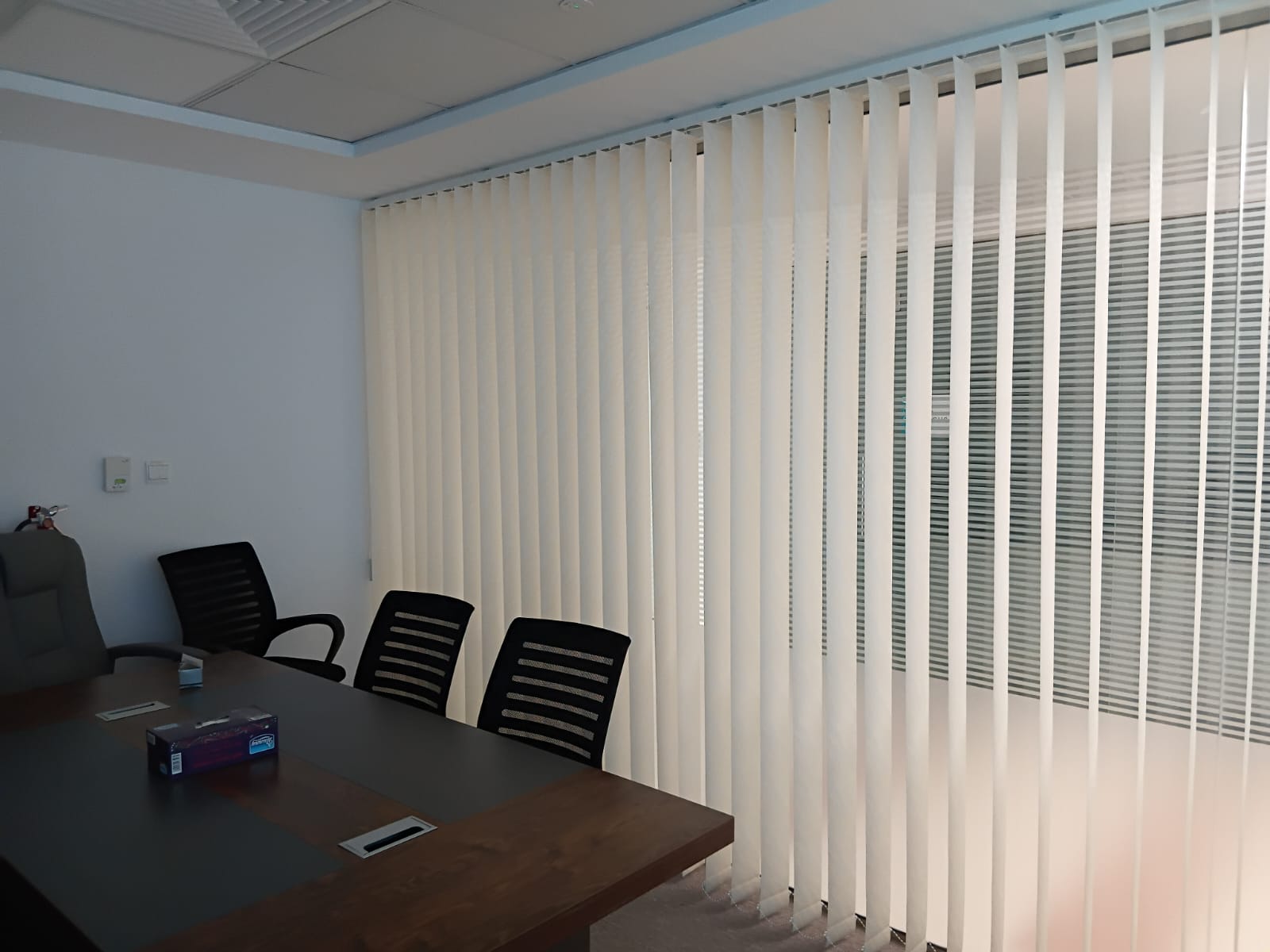 Cream vertical blinds along an office meeting room window